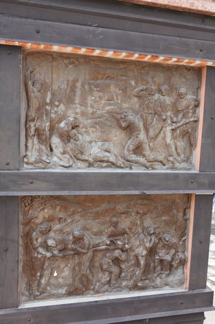 Rilievo bronzeo che rappresenta scene di lotta e commemorazione, situato nel Monumento ai Martiri del Panaro.