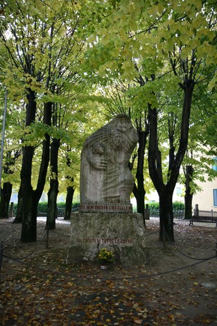 Monumento commemorativo ai caduti di Ambra, immerso nel verde degli alberi.