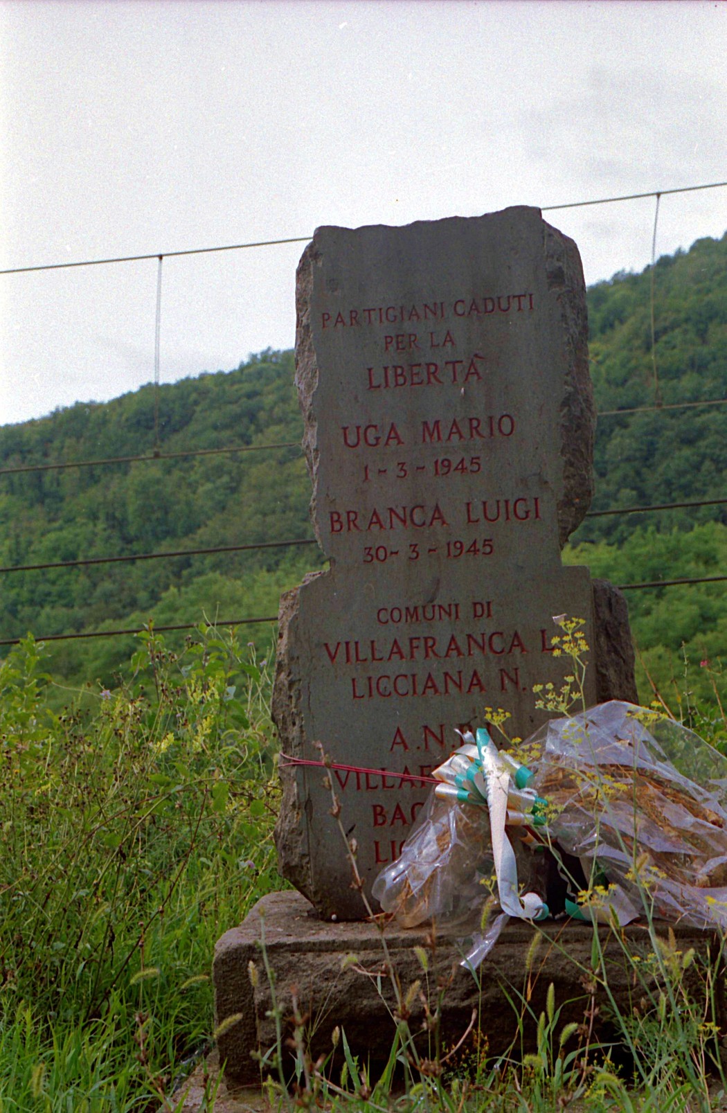 Cippo commemorativo dedicato ai partigiani Uga Mario e Branca Luigi, situato in un'area montana.