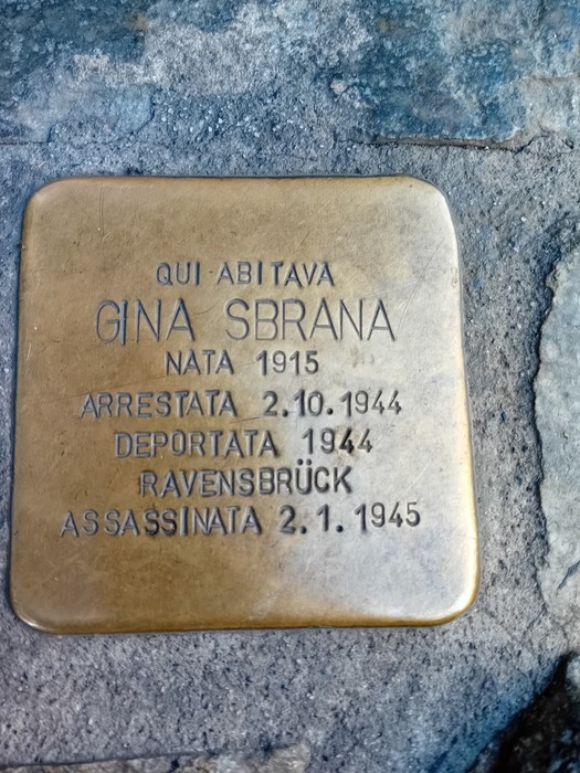 Pietra d'inciampo in ottone incassata nel selciato, con iscrizione dedicata a Gina Sbrana.