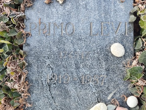 Sepolcro di Levi, caratterizzato da un'epigrafe semplice e decorato con pietre e vegetazione.