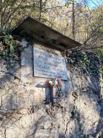 Lapide commemorativa dedicata a Carlo Olivieri, in un contesto naturale e storico.