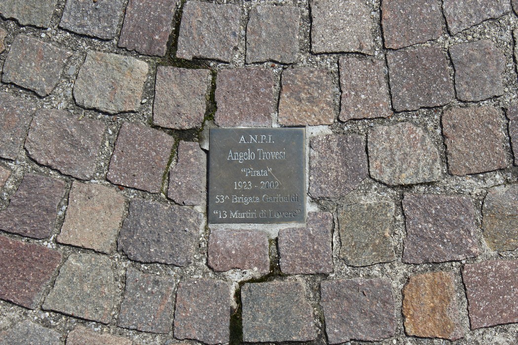 Pietre d'inciampo dedicate ai partigiani, in memoria di Angelo Trovetti, con dettagli sulla sua vita e impegno.