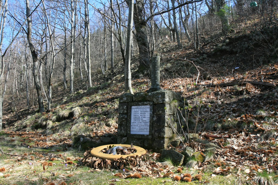Monumento di Serra, omaggio alla memoria, immerso nella natura e circondato da alberi e foglie.