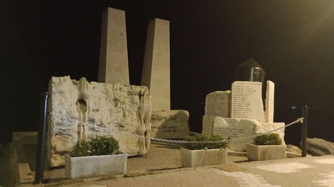 Monumento ai caduti, un omaggio commemorativo affacciato sul mare, in un'atmosfera notturna suggestiva.