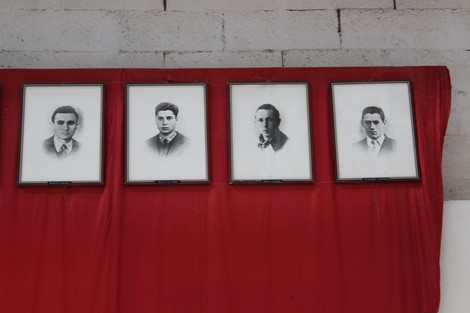 Monumento commemorativo con ritratti in bianco e nero su sfondo rosso dedicato ai caduti dell'Ansaldo Elettrotecnico.