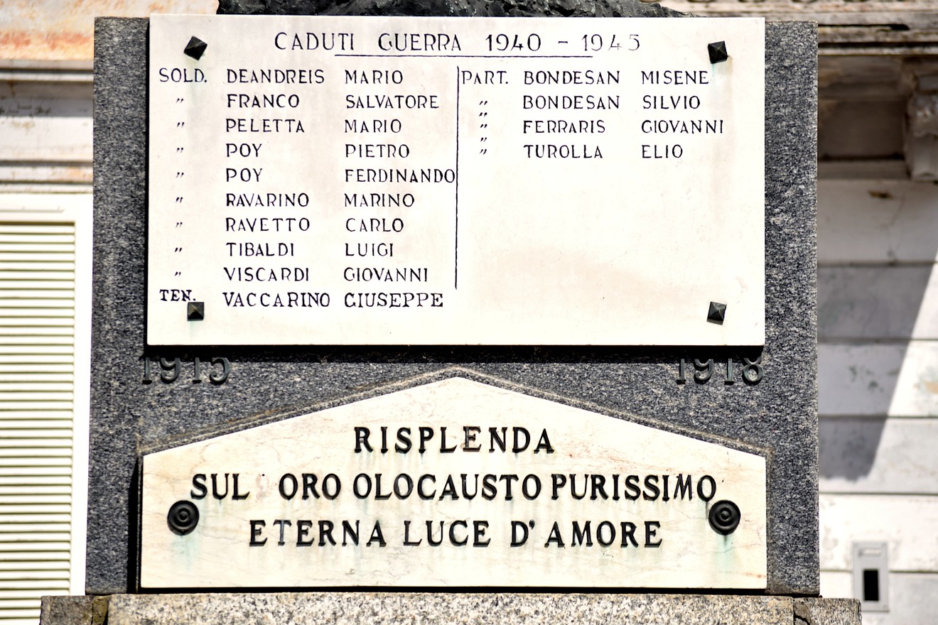 Monumento in pietra con lapidi in marmo e iscrizioni, addossato alla parete di un edificio.