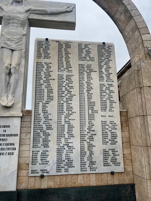 Monumento commemorativo con elenchi di nomi, simbolo di riconoscimento e memoria storica.