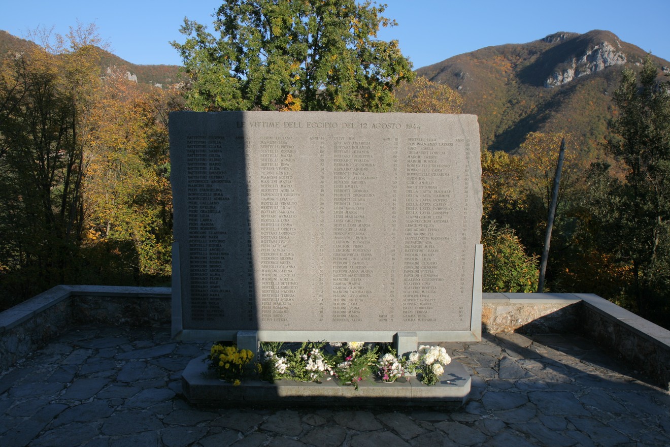 Lapide commemorativa delle vittime di Sant'Anna, immersa nella natura montana, in ricordo della tragedia.