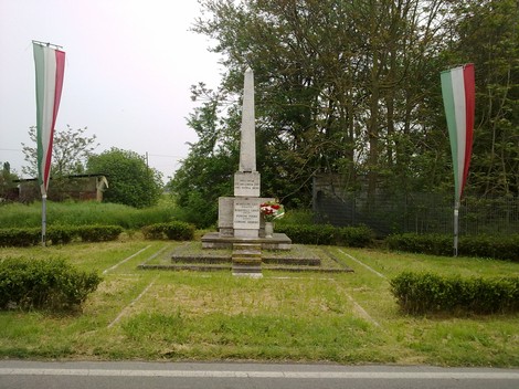 Monumento commemorativo dedicato a Morellini, Bosatelli, Foroni e Corgini, con decorazioni tricolori.