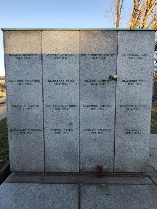 Monumento commemorativo nel Campo della Gloria con nomi incisi, simbolo di ricordo e onore ai caduti.