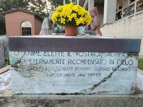 Sacrario dei Partigiani di Regnano con decorazioni floreali, simbolo di memoria e rispetto per i caduti.