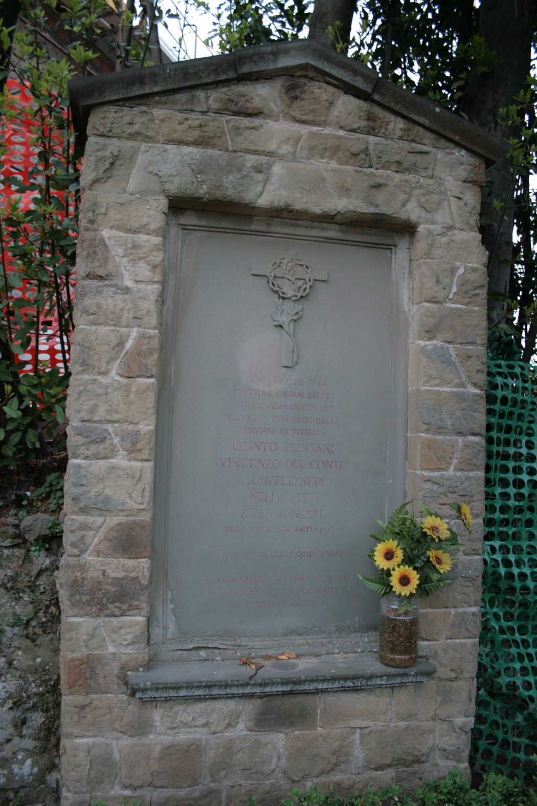 Tabernacolo dei caduti di Artimino, memoriale in pietra con un omaggio floreale.