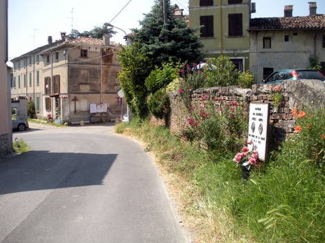 Lapide commemorativa ai fratelli Brambilla, situata lungo una strada in un contesto rurale.