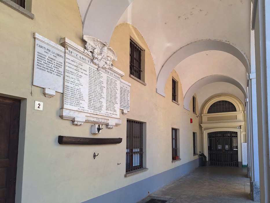 Lapidi commemorative ai caduti affisse su una parete all'interno di un portico.