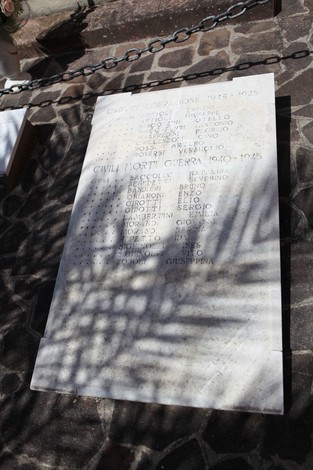 Monumento ai Caduti in marmo, con i nomi incisi dei soldati e civili morti durante le guerre. Ambiente suggestivo.
