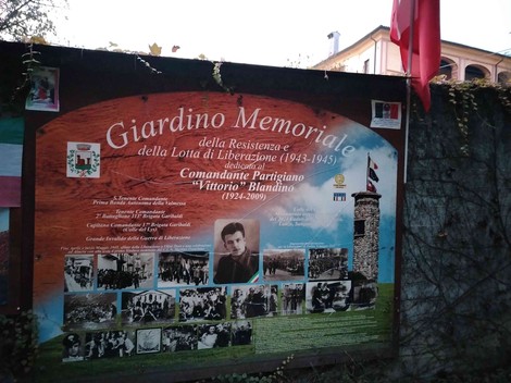 Giardino memoriale dedicato alla Resistenza e alla lotta per la libertà, con decorazioni e immagini storiche.