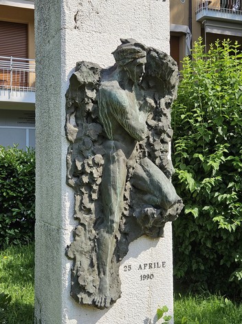 Monumento alla Resistenza con rilievo di figura umana su parete, decorato da vegetazione circostante.