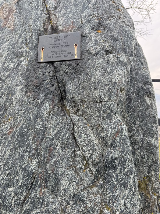 Targa metallica con iscrizione fissata su grande masso di roccia granitica.