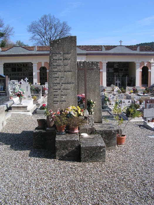 Sepolcro commemorativo dedicato ai caduti, adornato con fiori, situato nel cimitero del Palazzaccio.