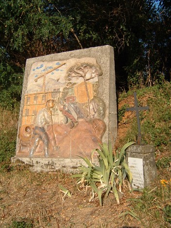 Monumento a Moggi e Fissi, rappresenta scene storiche con dettagli in rilievo e natura circostante.