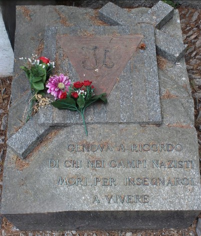 Monumento commemorativo ai deportati, con fiori e simboli, per ricordare le vittime dei campi nazisti.