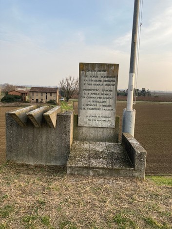 Monumento commemorativo per lo sfondamento della linea del Senio, con vista su campi e storia bellica.