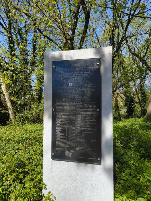 Memoriale del Gruppo Manouchian, un monumento commemorativo circondato da vegetazione lussureggiante.