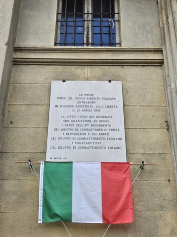 Lapide commemorativa all'ingresso dell'Esercito cobelligerante italiano a Bologna, con bandiera italiana.