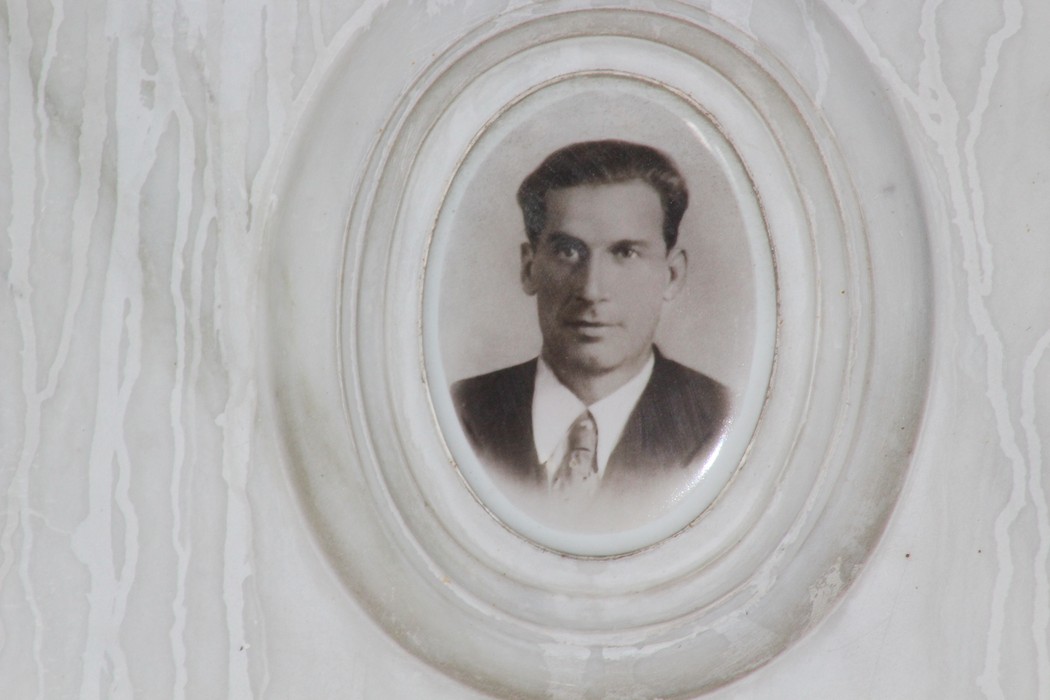 Sacrario dei partigiani di Torbella con un ritratto in bianco e nero di un uomo in giacca e cravatta.