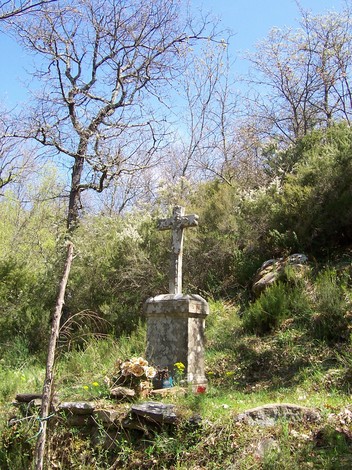 Cippo di Tugliano, monumento in una zona verde, circondato da alberi e fiori, simbolo di memoria e rispetto.