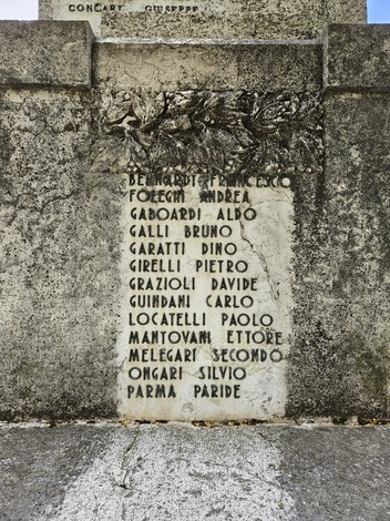 Monumento ai Caduti con iscrizioni in memoria dei soldati, ornato da elementi decorativi in pietra.