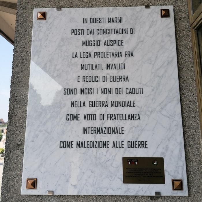 Targa commemorativa dedicata ai caduti di guerra, incisa su marmo, con nomi e messaggi di fratellanza.
