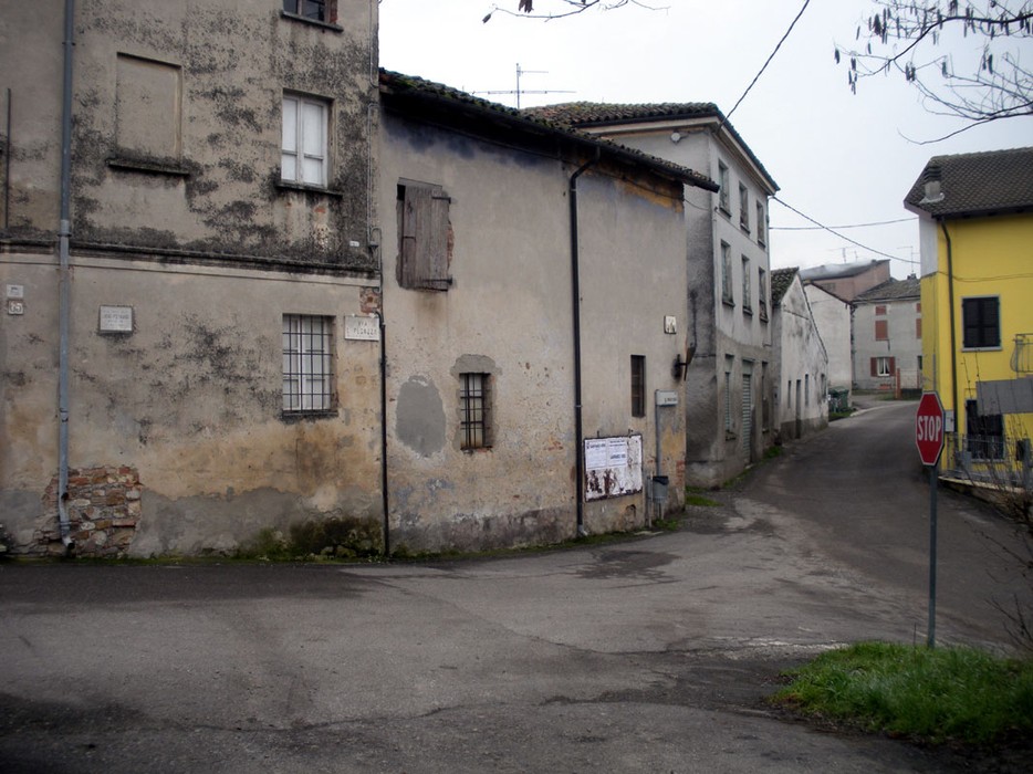 Lapide a Losio: vista di una strada con edifici storici e un segnale di stop. Atmosfera di un paese tranquillo.