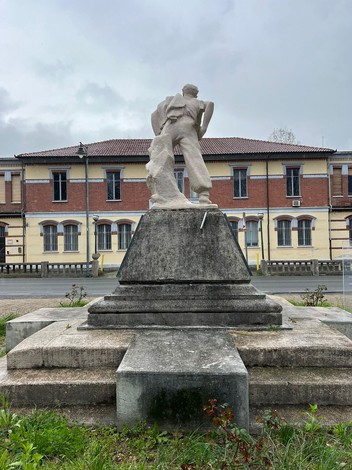 Monumento al partigiano che celebra la resistenza, con statua su pedestal in un contesto urbano.