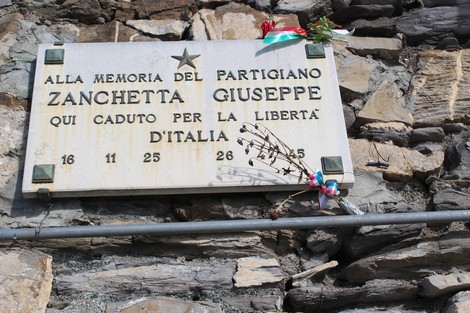 Lapide commemorativa in memoria del partigiano Zanchetta Giuseppe, situata su un muro di pietra.