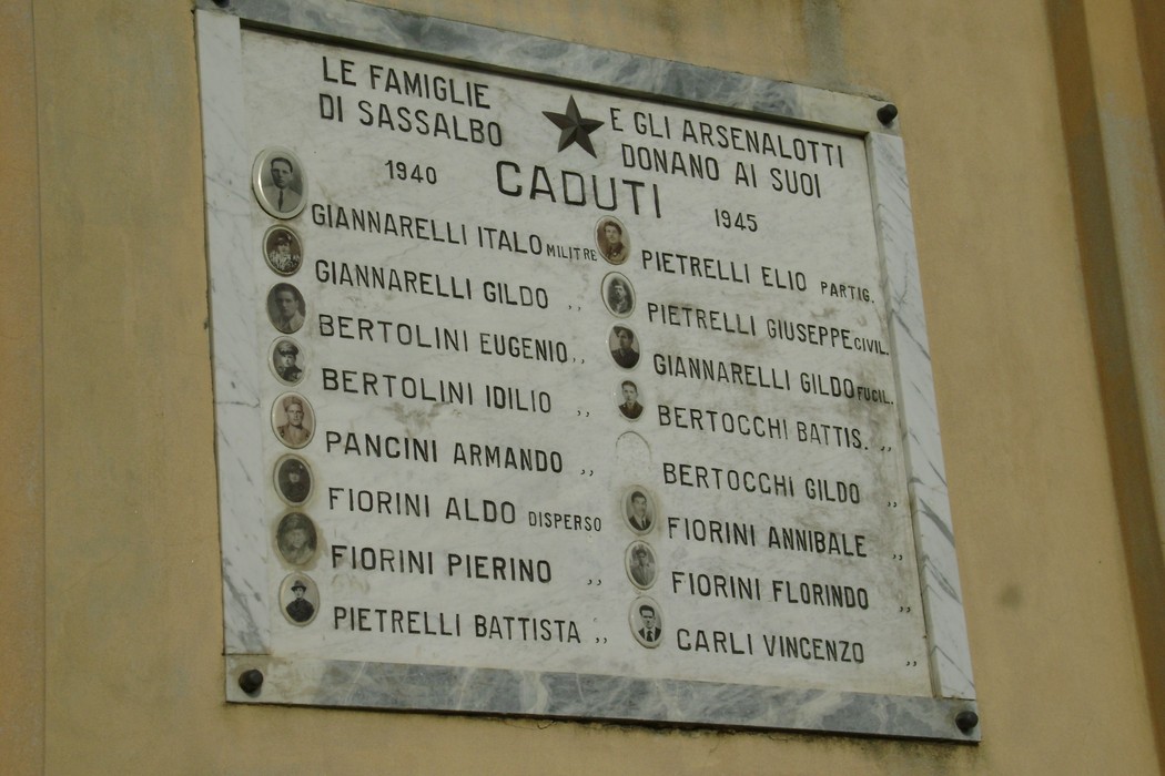 Lapide commemorativa ai caduti di Sassalbo, con nomi e date di chi ha sacrificato la vita per la patria.