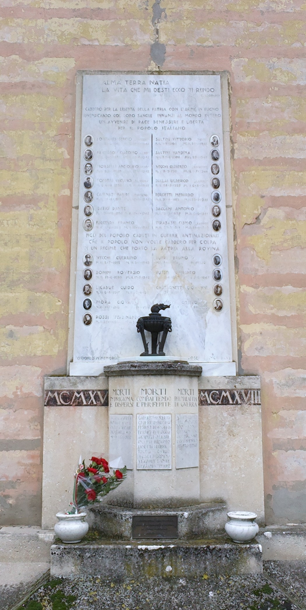Lapide commemorativa in onore dei caduti di Fosdondo, con elenchi di nomi e simboli.