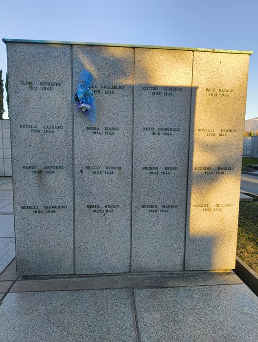 Monumento commemorativo con nomi incisi, dedicato ai caduti, in un ambiente tranquillo e solenne.