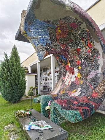Monumento ai martiri della Creda, commemorazione dei caduti con architettura contemporanea e decorazioni colorate.
