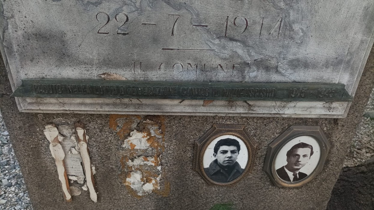 Stele commemorativa con fotografie e incisioni, dedicata a persone del passato. Dettagli storici visibili.