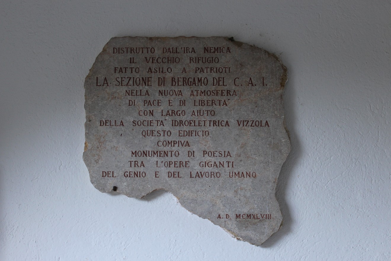 Lapide commemorativa al Rifugio Laghi Gemelli, dedicata ai patrioti e al monumento di poesia.