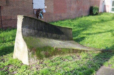 Struttura di pietra monumentale in un'area verde, simbolo della Resistenza, immersa nella natura.