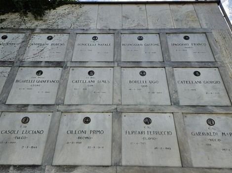 Monumento ai Caduti Partigiani, con targhe commemorative dei combattenti. Atmosfera di rispetto e memoria storica.