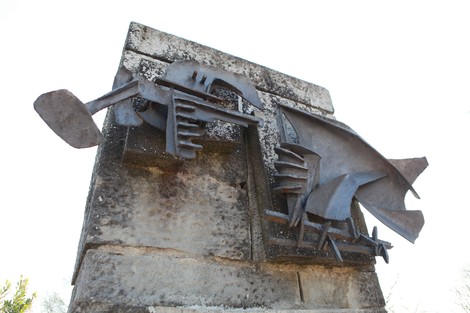 Monumento in metallo dedicato ai caduti del Tiro a segno nazionale, con forme stilizzate e dettagli geometrici.