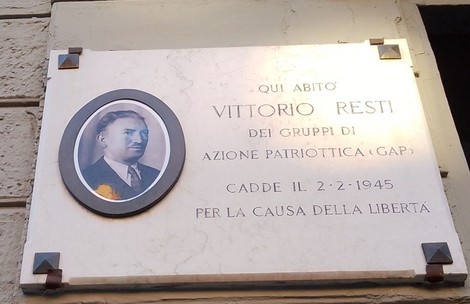 Lapide commemorativa dedicata a Vittorio Resti, attivista per la libertà, situata su una parete.