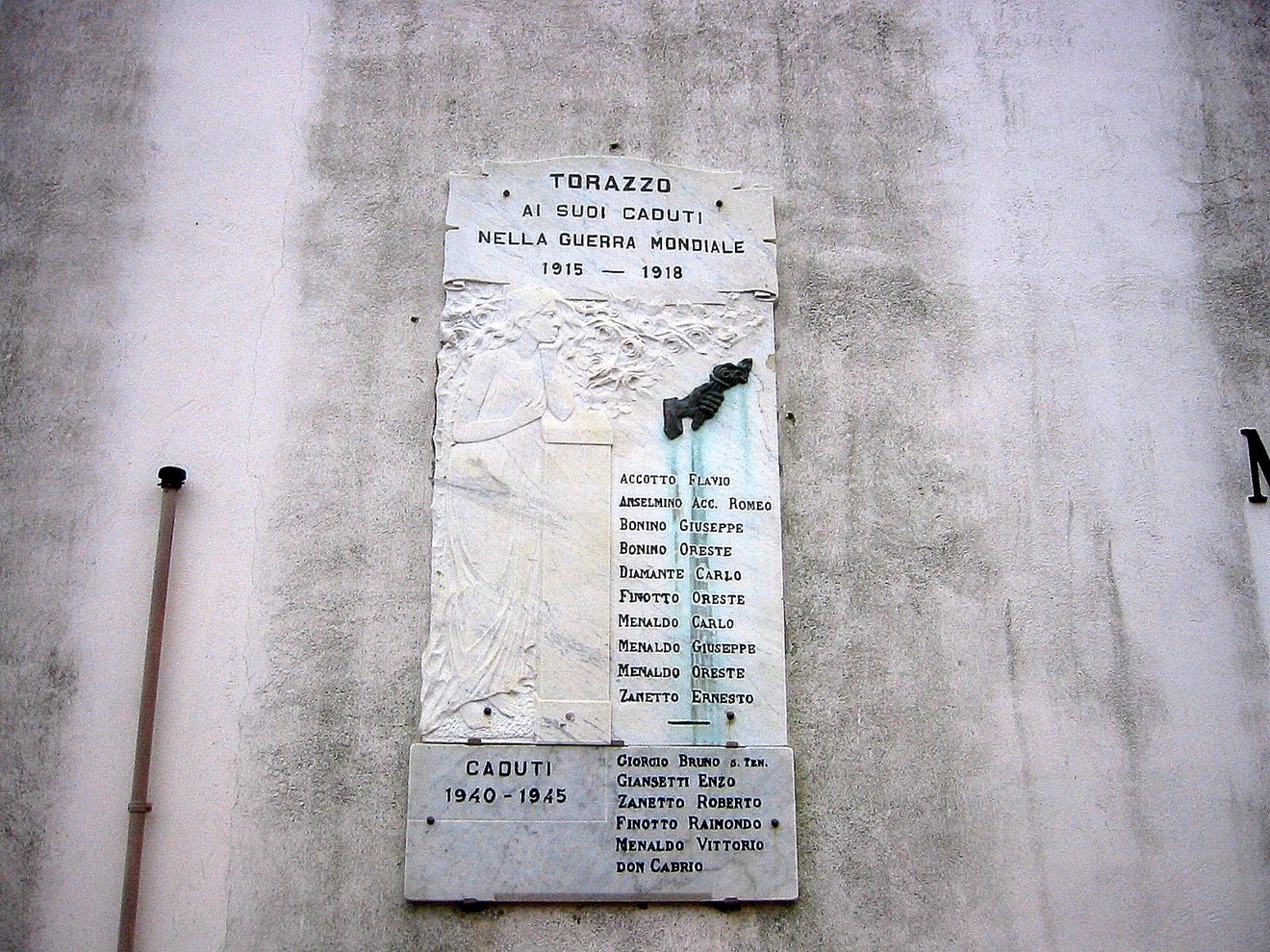 Lapide commemorativa dedicata ai caduti di Torrazzo nelle due guerre mondiali, con nomi e simboli memoriali.