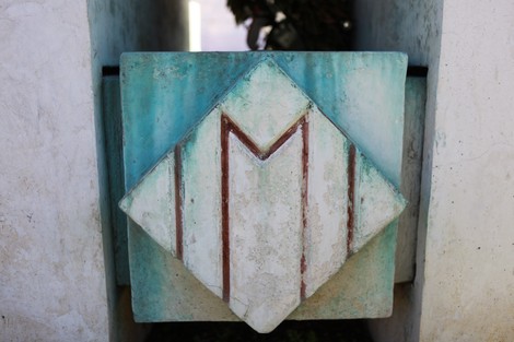 Dettaglio dell'opera commemorativa del Monumento agli Internati Militari italiani, con elementi stilizzati e colori verde-blu.