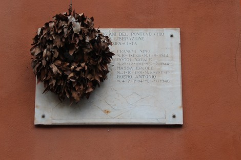 Lapide commemorativa con corona di foglie, dedicata ai caduti partigiani di Pontevecchio.