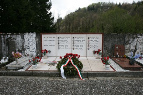 Tomba dei partigiani, commemorazione dei caduti, decorata con fiori e un tricolore italiano.